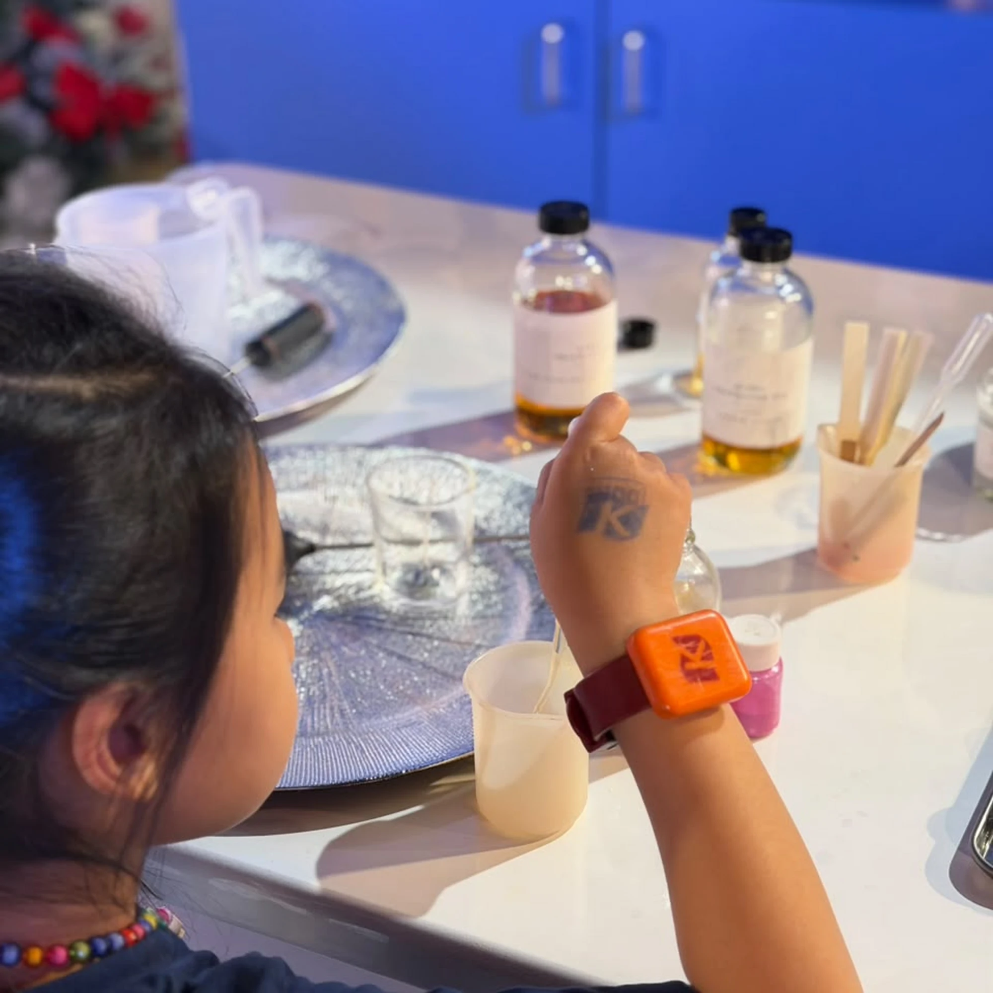 Kids decorating candle tins before making scented candles during a Studio Kinza creative workshop in Dubai