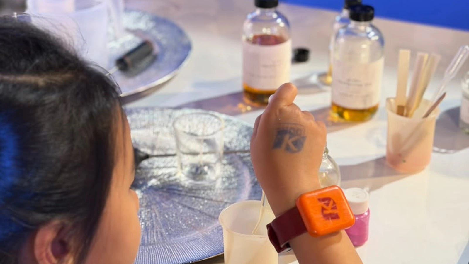 Studio Kinza children's crafting station with colorful wax decor, scent bottles, and safe tools
