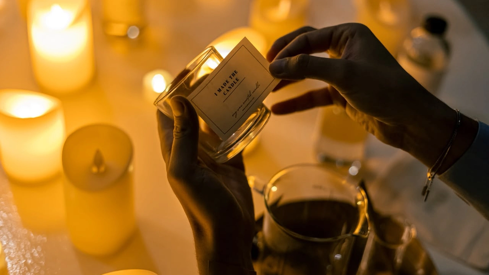 Elegant live candle bar reception station with guests customizing soy candle favors in Dubai