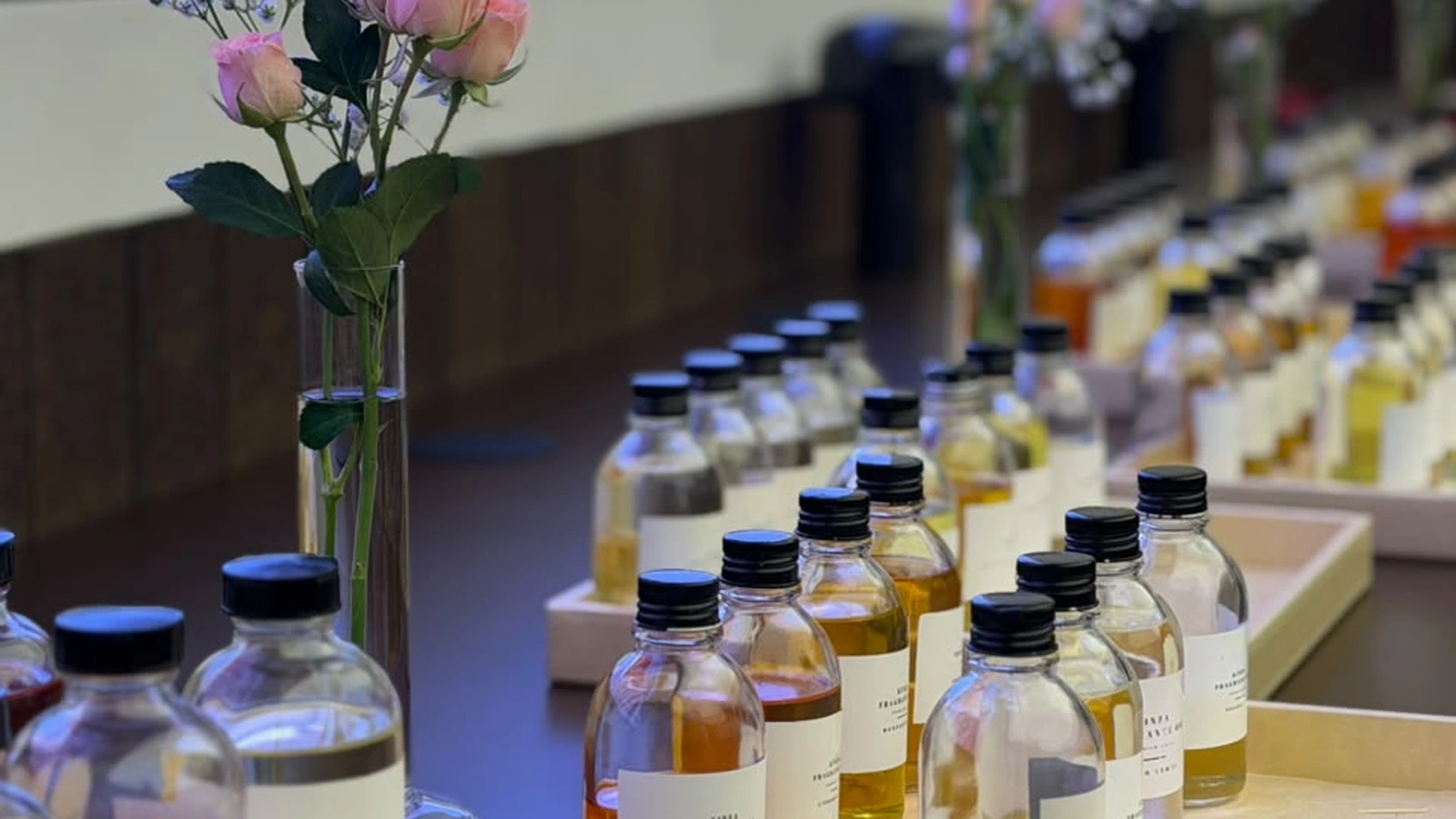 Studio Kinza fragrance bar displaying perfume droppers, raw botanical notes, and soy wax candles
