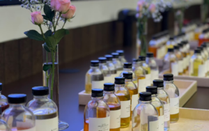 Labeled amber bottles of floral, woody, citrus, and gourmand fragrance oils for candle making