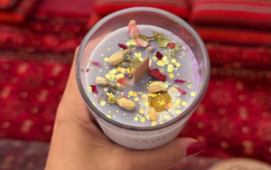 Hand pouring natural soy wax and clean fragrance oils into a minimalist glass candle jar in Dubai