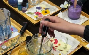 Molten soy candle wax forming a clear, even melt pool around a centered burning wick