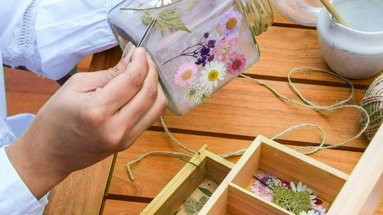 Teenager carefully pouring melted soy wax into a glass candle vessel during a birthday workshop in Dubai